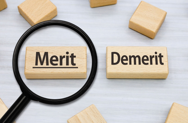 meritと書かれたブロックとルーペ