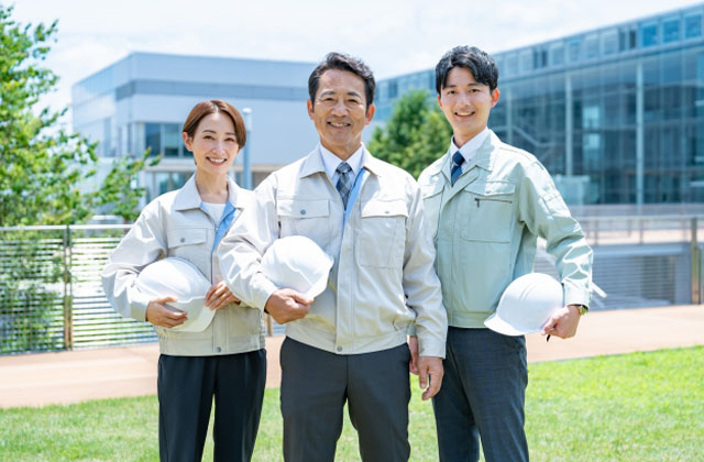 ヘルメットを抱えた作業服の三人