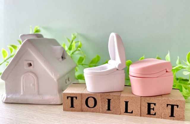 TOILETと書かれたブロックと家とトイレの模型2つ