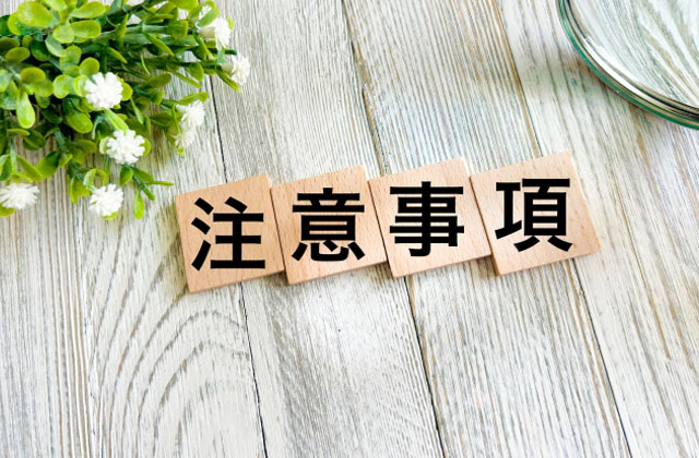 注意事項と書かれた木のブロックと植物