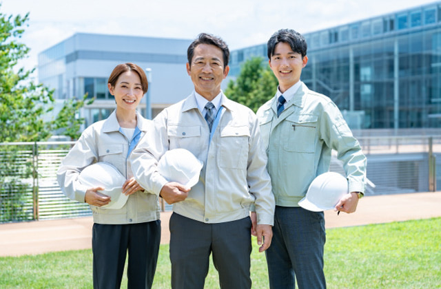 ヘルメットを抱えて笑っているリフォーム業者3人