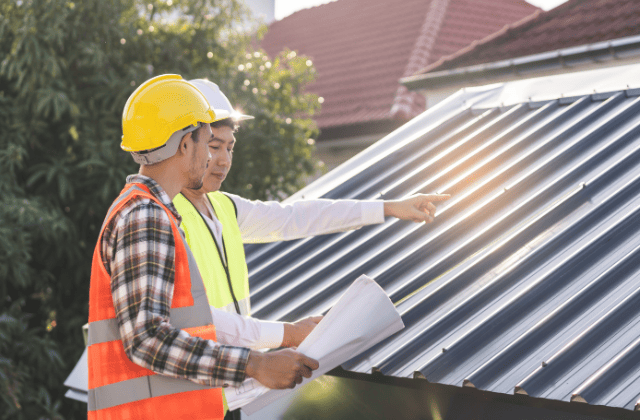 屋根を指さして相談する業者たち