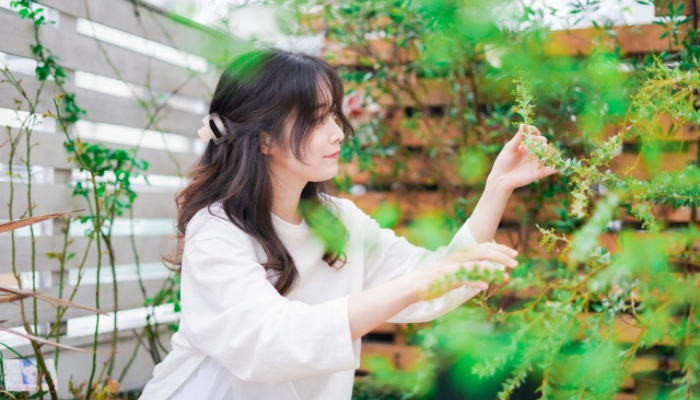 ベランダで家庭菜園をする女性
