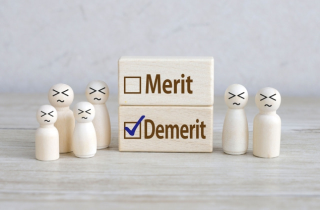 Demeritと書かれたブロックと人形6体