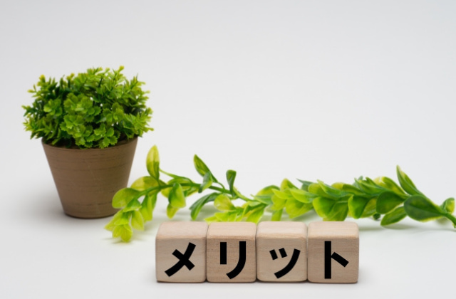 メリットと書かれたブロックと植物