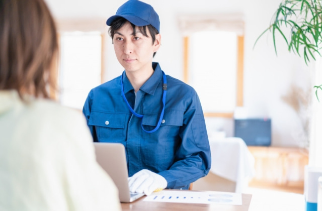 クライアントと話している作業服の男性