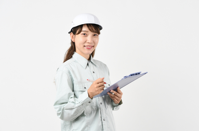ヘルメットを被っている作業服の女性
