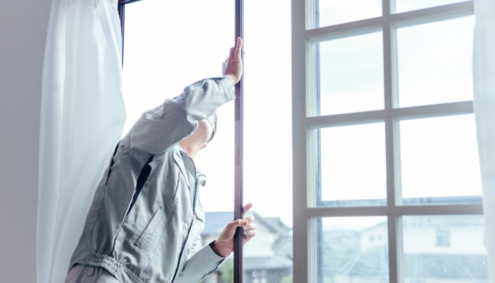 窓のサッシを確認する作業男性