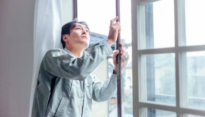 窓サッシをチェックする男性作業員